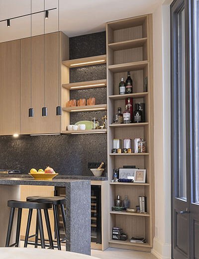 Cuina oberta amb illa de pedra i fusta natural a Sitges