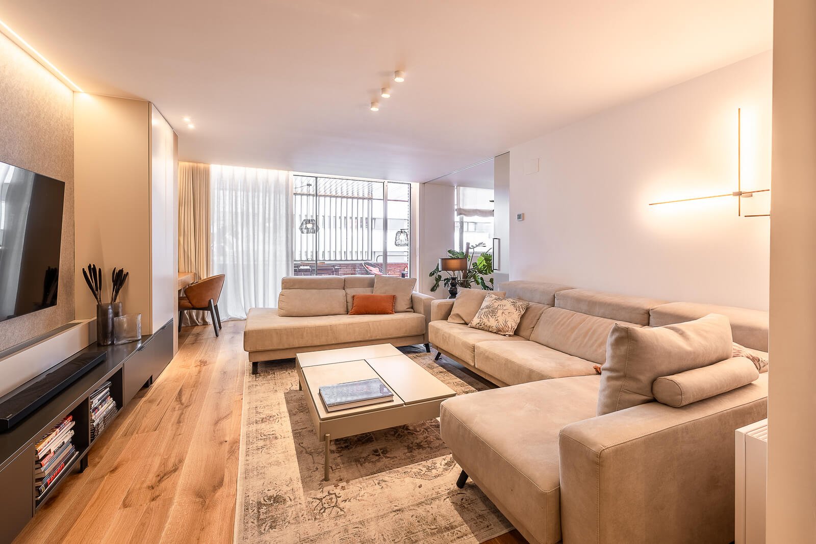 Saló amb sofà i tons càlids al Pis Calatrava de Barcelona